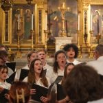 Grupo coral cantando en el interior de una iglesia