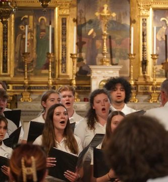 Grupo coral cantando en el interior de una iglesia