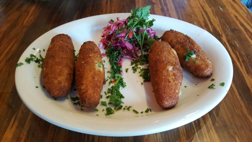 Croquetas doradas en un plato, fotografía ilustrativa de croquetas de setas y turrón