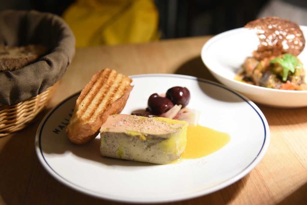 Foie gras con tostadas y olivas, presentación ilustrativa de canapé de foie y turrón