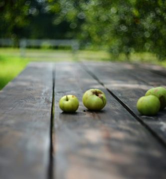 Manzanas verdes sobre mesa de madera, fotografía ilustrativa para artículo de turrón de manzana ahumada
