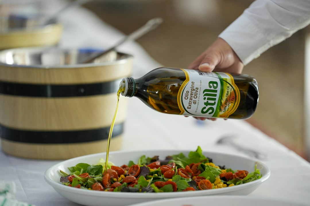 Aliño vertiéndose sobre una ensalada, fotografía ilustrativa de vinagreta con turrón