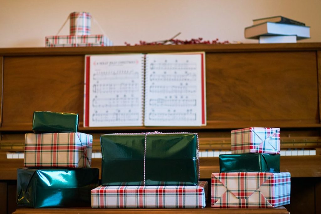 Piano con partituras y regalos navideños