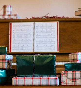 Piano con partituras y regalos navideños