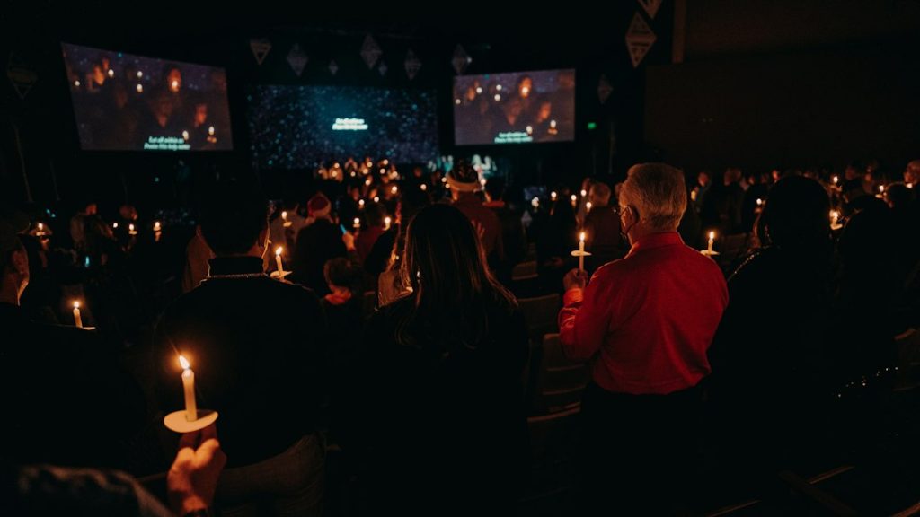 Participantes sosteniendo velas durante una celebración