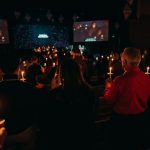 Participantes sosteniendo velas durante una celebración