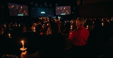 Participantes sosteniendo velas durante una celebración