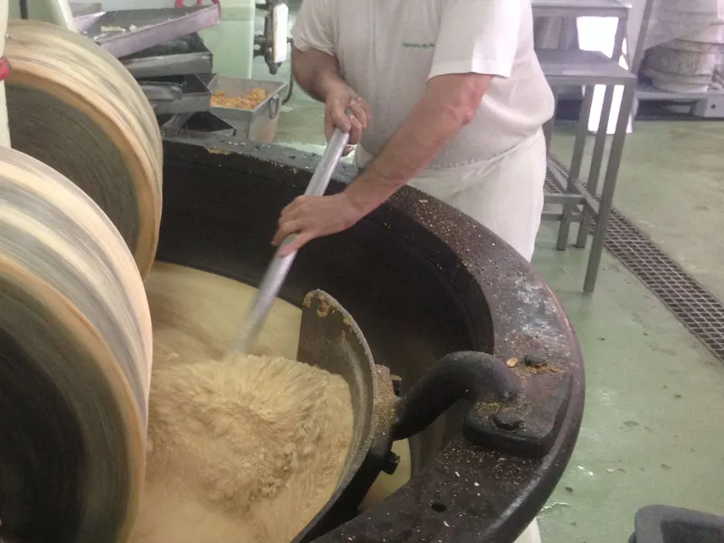 Maestro turronero batiendo turr&oacute;n de Jijona en el boixet del obrador